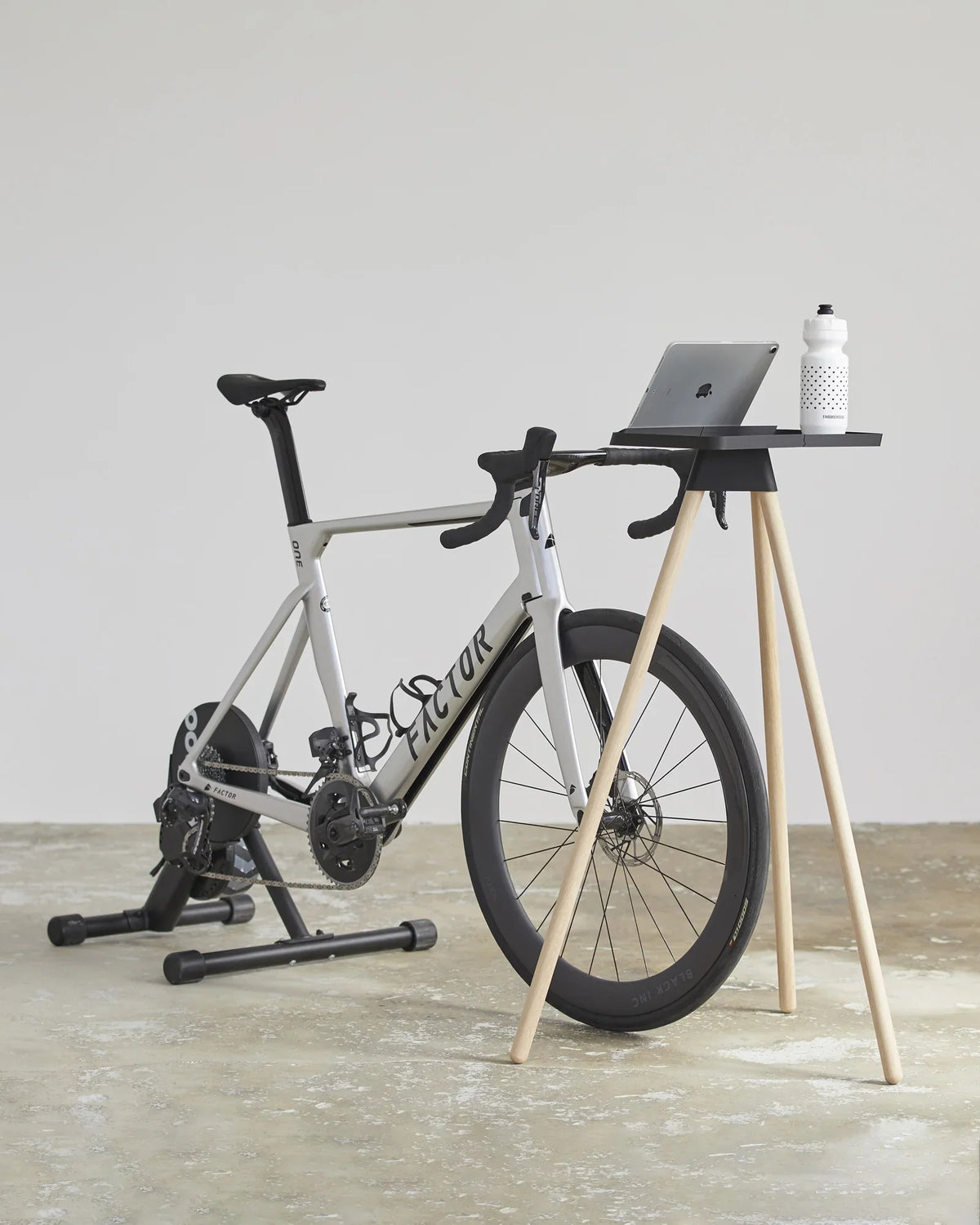 Racercykel på hometrainer med Tons Race Table, laptop og drikkedunk foran styret